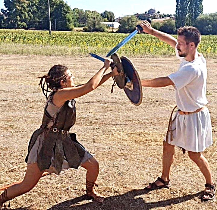 Dos personas luchando con escudo y espadas